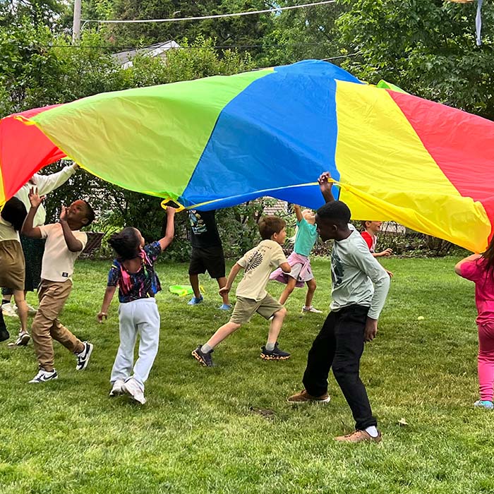 Kids outdoors playing with parachute